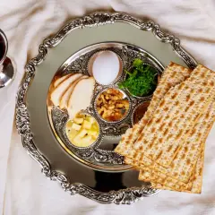 Talerz z symbolami jedzenia koszernego na Pesach: macą, jajkiem, warzywami i mięsem. Obok kielich z winem.