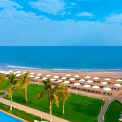 Piękna plaża z palmami i basenem, idealne miejsce na wakacje. Barcelo Mussanah Resort opinie potwierdzają rajski wypoczynek.