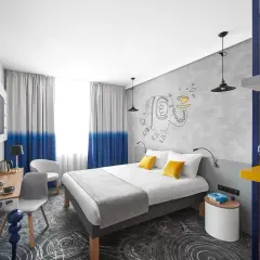 Pokój w hotelu Ibis z łóżkiem, biurkiem i rysunkiem słonia.