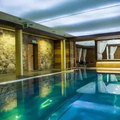 Basen w hotelu Aubrecht Country Spa Resort. Kamienne ściany i zasłonięte baldachimy tworzą atmosferę relaksu, idealną do czytania hotel aubrecht country spa resort opinie.