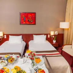 Pokój hotelowy z dwoma łóżkami, śniadaniem na tacy i bukietem róż. Idealne miejsce na pobyt, zgodnie z premier kraków hotel opinie.