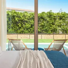 Pokój z widokiem na basen i ogród. Wygodne łóżko, logo Azure. Wiele pozytywnych azure resort & spa opinie potwierdza ten widok.