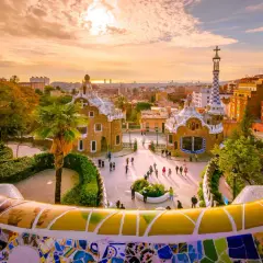 Park Güell w Barcelonie, jedno z najlepszych miast do odwiedzenia w Hiszpanii, zachwyca mozaikową ławką i bajkowymi budynkami o zachodzie słońca.