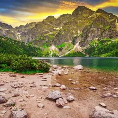 Górskie jezioro Morskie Oko, jedno z najpiękniejszych miejsc w Polsce, otoczone zielonymi zboczami i skalistymi szczytami.