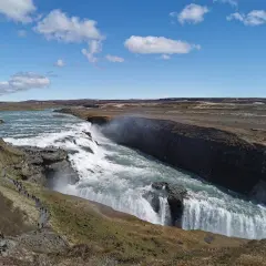 Potężny wodospad Gullfoss, część islandzkiego Złotego Kręgu, z turystami na ścieżce widokowej.