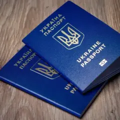 Dwa niebieskie paszporty Ukrainy leżą na drewnianym blacie. Czy do Turcji potrzebny jest paszport? Tak, do podróży potrzebny jest paszport.