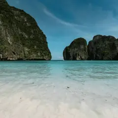 Rajska zatoka Maya Bay z turkusową wodą i stromymi, porośniętymi zielenią klifami.
