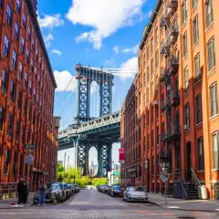 Urokliwe dzielnice Nowego Jorku: Manhattan Bridge wyłaniający się między ceglanymi kamienicami z DUMBO.