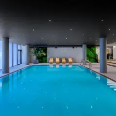 Basen w AC Hotels Krakow. Relaks przy basenie z widokiem na zielone ściany i nowoczesne leżaki.