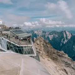 Tłum turystów na tarasie widokowym najwyższego szczytu Niemiec, Zugspitze, podziwia alpejskie krajobrazy.