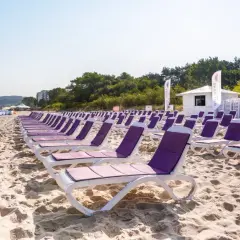 Rzędy leżaków na piaszczystej plaży, idealne na tanie wczasy nad morzem dla 2 osób z wyżywieniem.