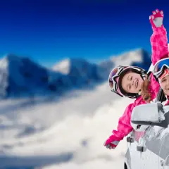 Radosne ferie lubuskie! Mama i córka w narciarskim stroju wychylają się z samochodu na tle ośnieżonych gór.
