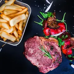 Soczysty stek z frytkami i grillowanymi warzywami. Warto sprawdzić karczma u fiakra opinie, bo danie wygląda wyśmienicie!