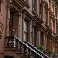 Eleganckie kamienice w stylu brownstone, typowe dla dzielnicy Harlem, z ozdobnymi gzymsami i kutymi balustradami schodów.