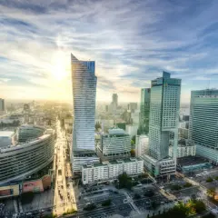 Słoneczny dzień nad nowoczesną lewobrzeżną dzielnicą Warszawy. Wysokie budynki biurowe i mieszkalne tworzą imponującą panoramę miasta.