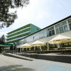 Zielone sanatorium z balkonami i tarasem z parasolami. Idealne miejsce na tanie sanatorium prywatnie.