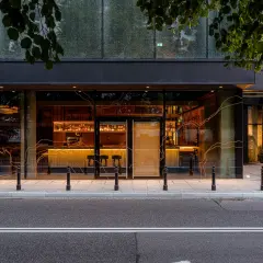 Elegancki bar i restauracja w hotelu Nobu Warszawa, widoczne przez duże okna od strony ulicy.