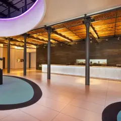Nowoczesne wnętrze hotelu, recepcja z podświetlanym blatem. Wiele pozytywnych andel's hotel łódź opinie potwierdza ten stylowy design.