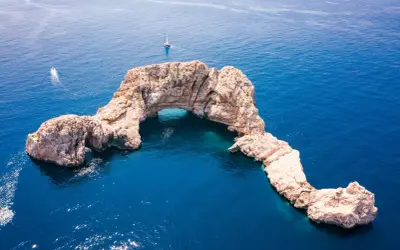 Skalny łuk na Balearach, jakie wyspy zachwycają turkusową wodą i żaglówkami.