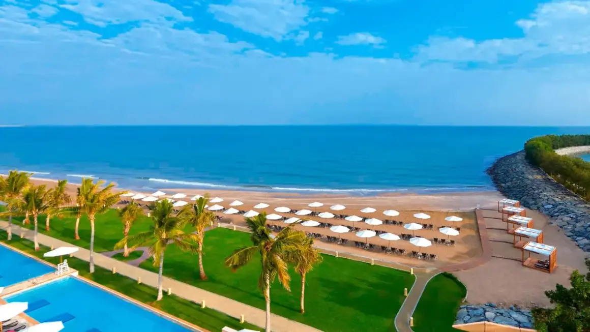 Piękna plaża z palmami i basenem, idealne miejsce na wakacje. Barcelo Mussanah Resort opinie potwierdzają rajski wypoczynek.
