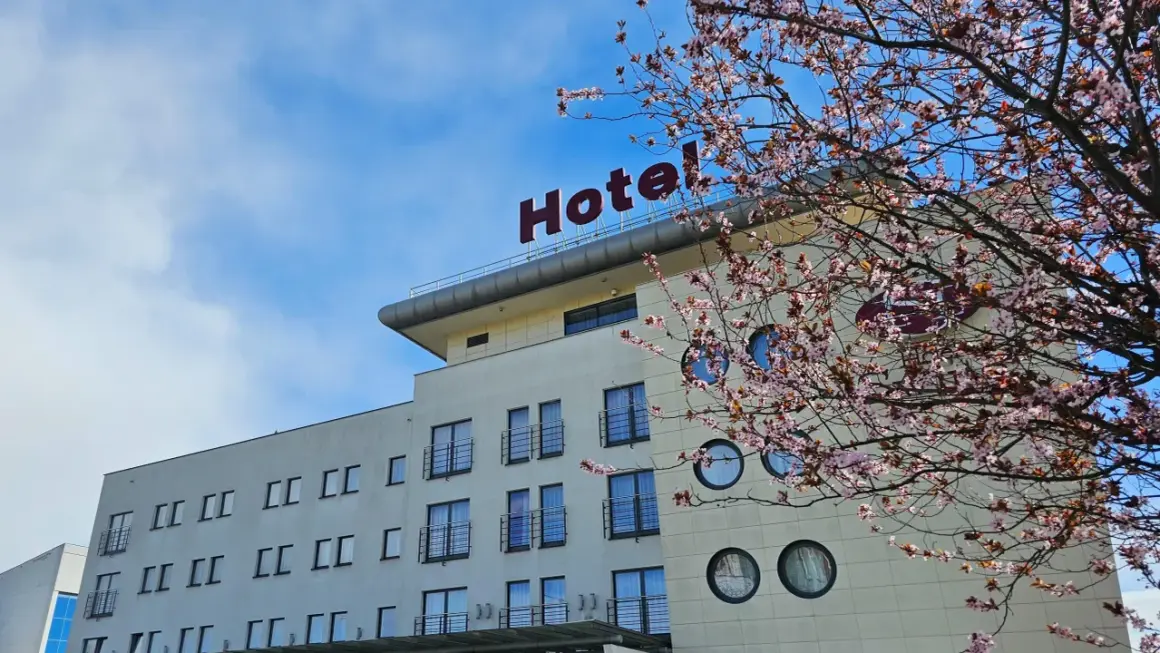 Nowe hotelowe opinie o hotelu z kwitnącą wiśnią w tle.