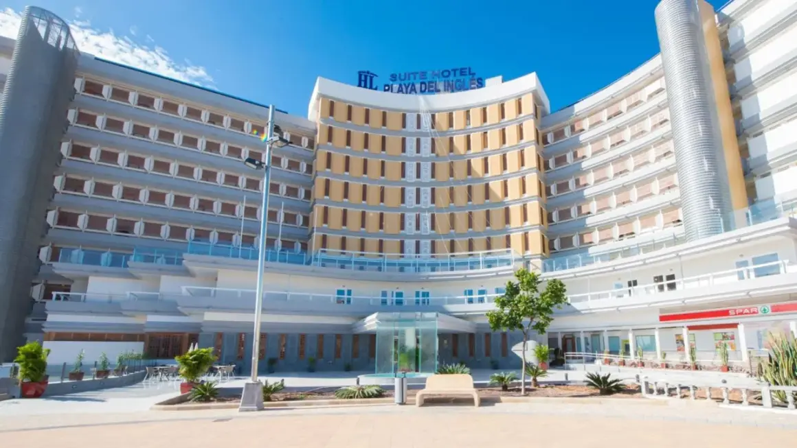 Nowoczesny hotel Suite Hotel Playa del Inglés z charakterystyczną, zakrzywioną fasadą i licznymi balkonami.