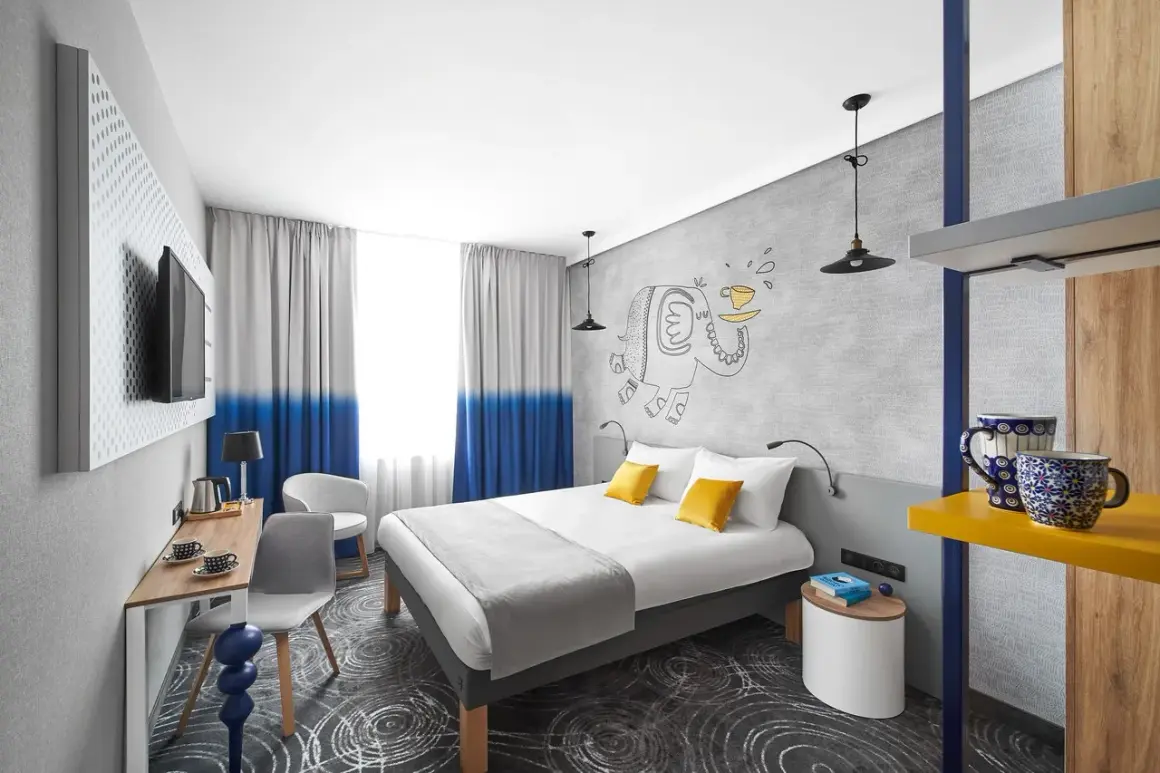 Pokój w hotelu Ibis z łóżkiem, biurkiem i rysunkiem słonia.