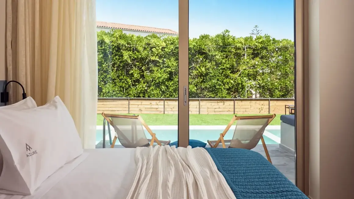 Pokój z widokiem na basen i ogród. Wygodne łóżko, logo Azure. Wiele pozytywnych azure resort & spa opinie potwierdza ten widok.