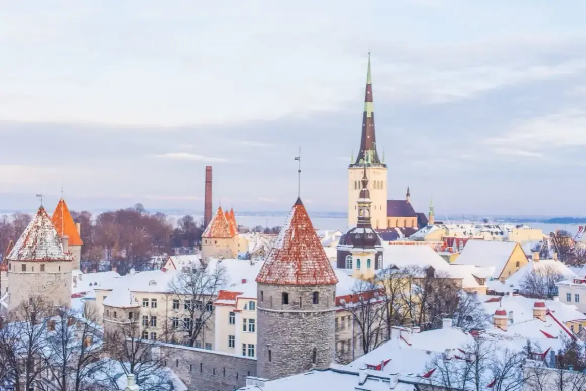 Zimowy widok na średniowieczne wieże i dachy pokryte śniegiem w Tallinnie, stolicy Estonii.