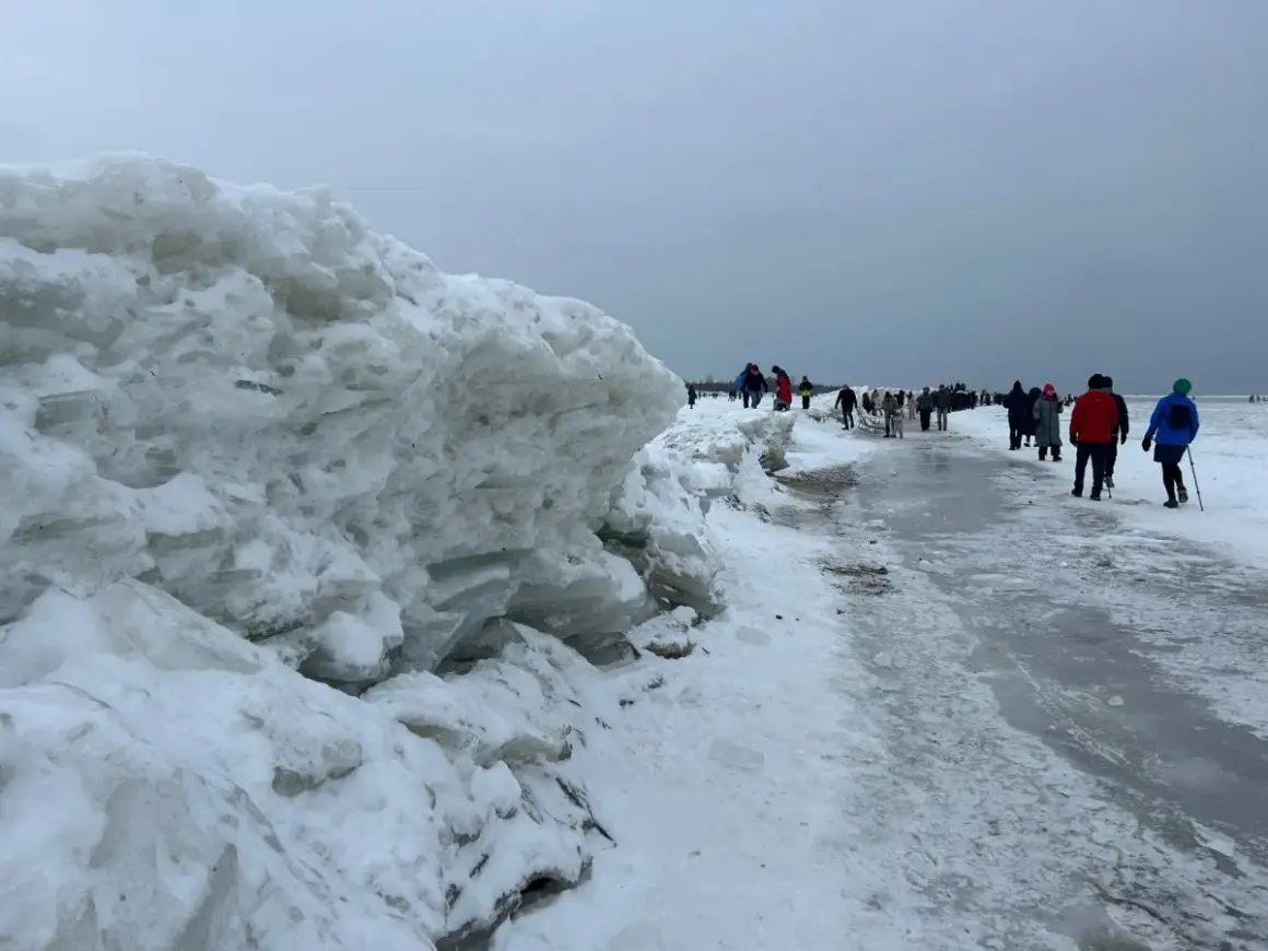 Mikoszewo: imponujące góry lodowe na plaży, ludzie spacerują po zamarzniętym brzegu.