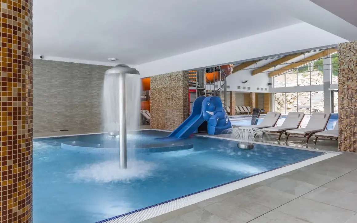 Basen z atrakcjami: zjeżdżalnia w kształcie słonia, wodospad i leżaki. Idealne miejsce na rodzinny wypoczynek, zgodnie z pozytywnymi **blue mountain resort opinie**.