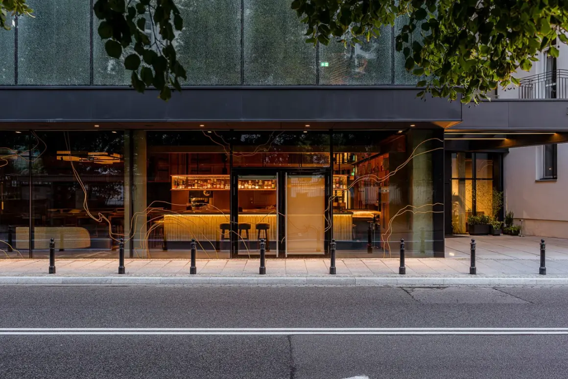 Elegancki bar i restauracja w hotelu Nobu Warszawa, widoczne przez duże okna od strony ulicy.