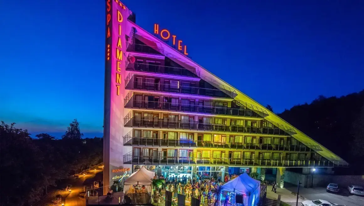 Hotel Diament Ustroń nocą, z neonami "SPA" i "HOTEL". Wiele pozytywnych **spa & wellness hotel diament ustroń opinie** potwierdza jego wyjątkowość.
