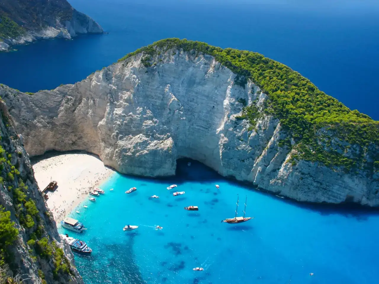Navagio Beach, jedna z najpiękniejszych wysp greckich, z turkusową wodą, białym piaskiem i łodziami.