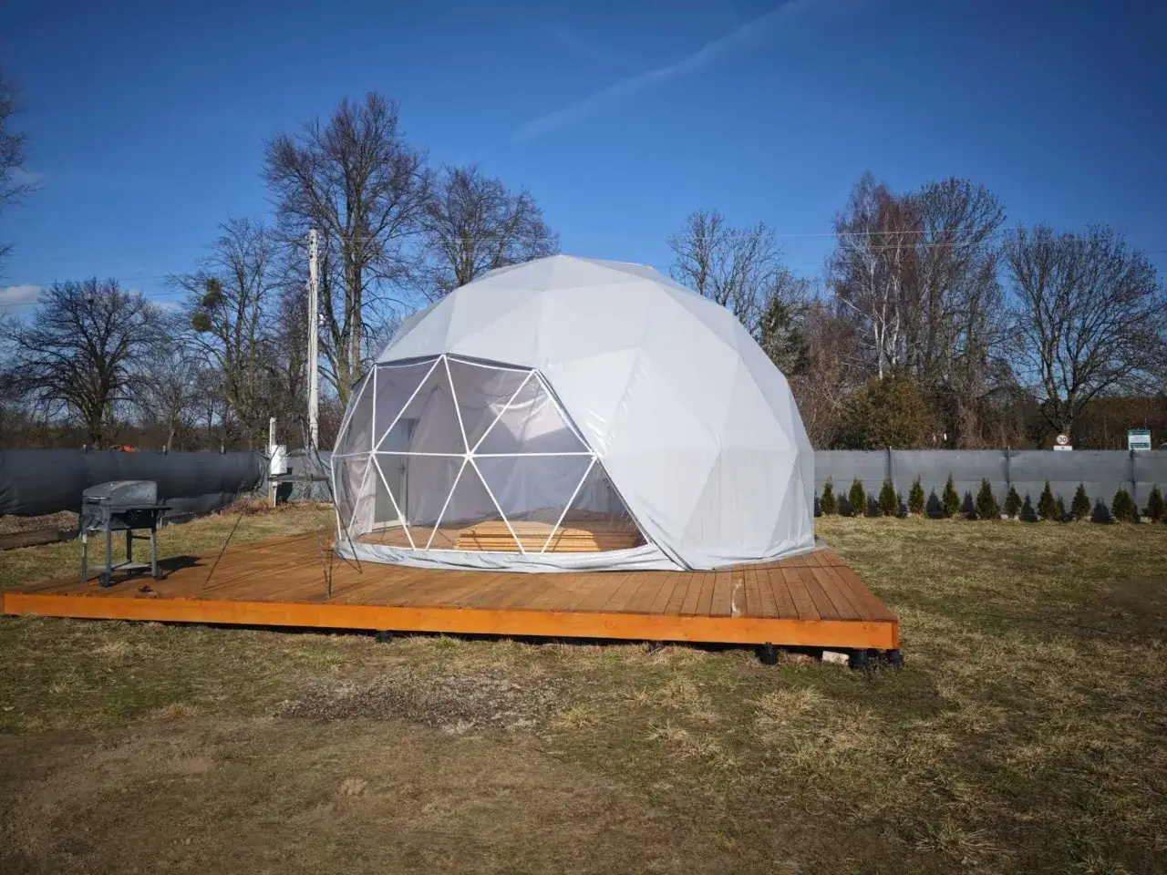 Glamping co to? Nowoczesna kopuła na drewnianym tarasie, z grillem obok. Idealne miejsce na luksusowy wypoczynek na łonie natury.