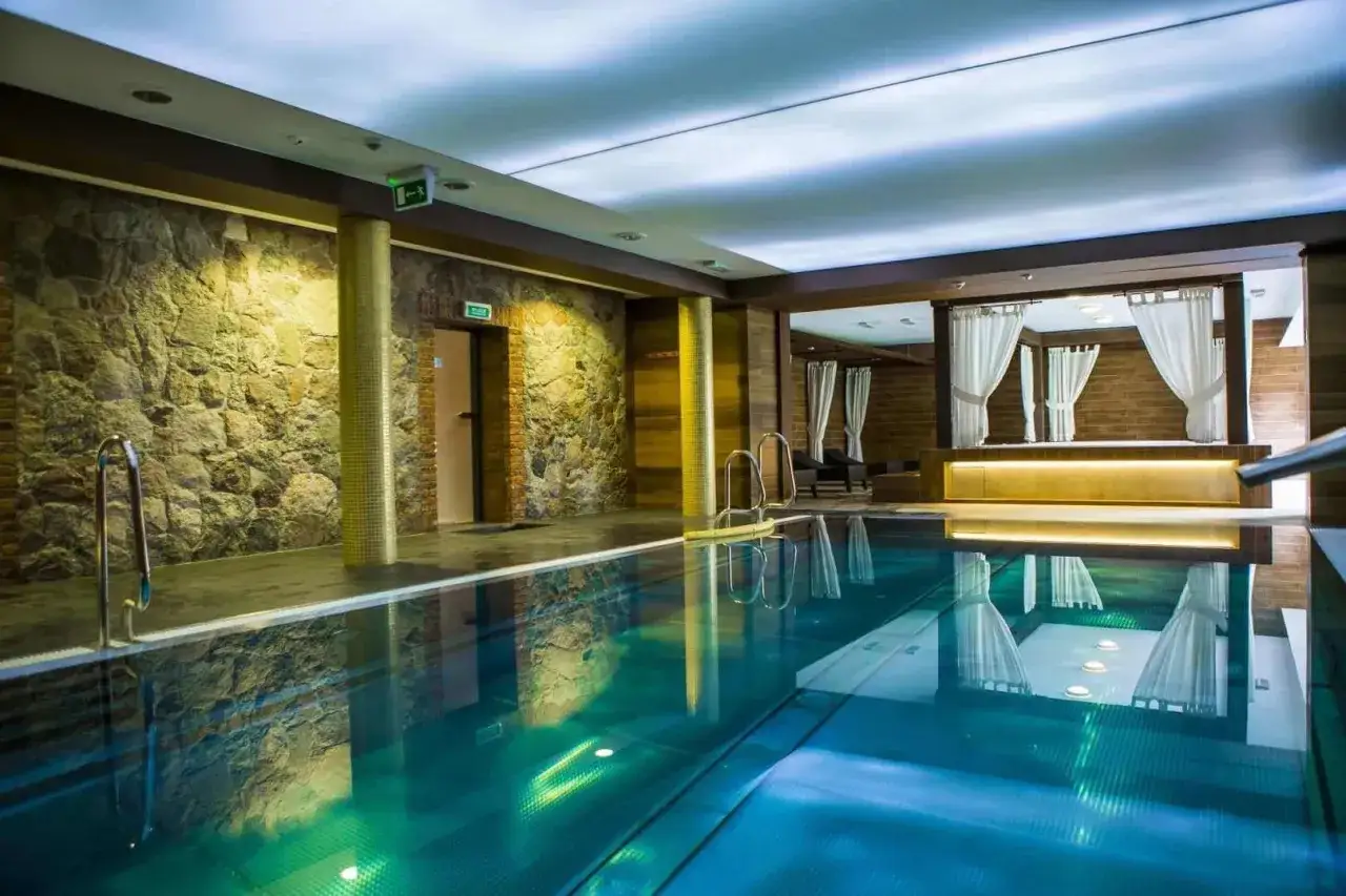 Basen w hotelu Aubrecht Country Spa Resort. Kamienne ściany i eleganckie zasłony tworzą atmosferę relaksu. Opinie gości potwierdzają wysoki standard.