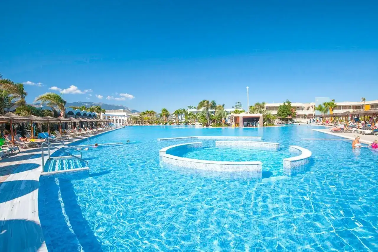 Ogromny basen z palmami i leżakami. Woda jest krystalicznie czysta, idealna do relaksu. Wiele osób chwali to miejsce w blue lagoon resort opinie.