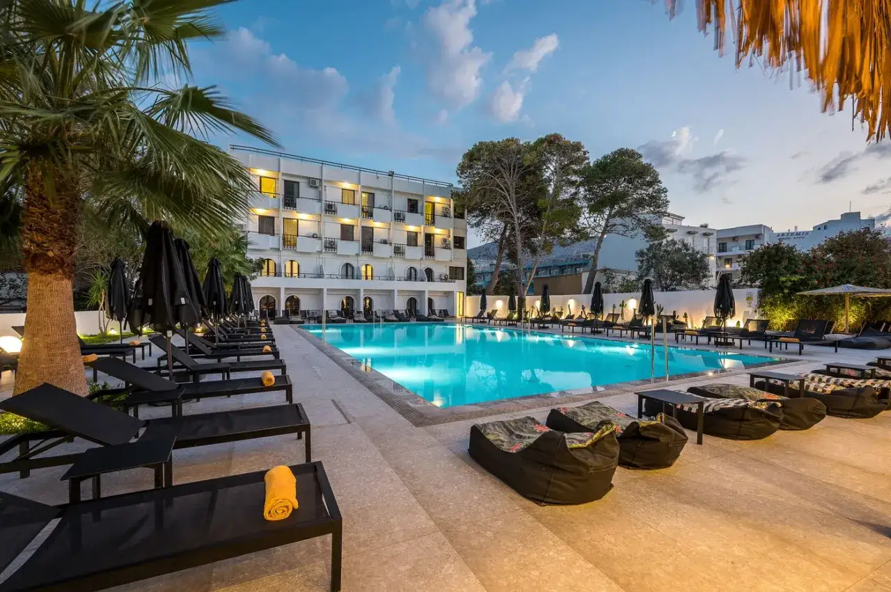 Basen i leżaki przy hotelu, idealne miejsce na relaks. Wiele osób szuka Heronissos Hotel opinie przed rezerwacją.