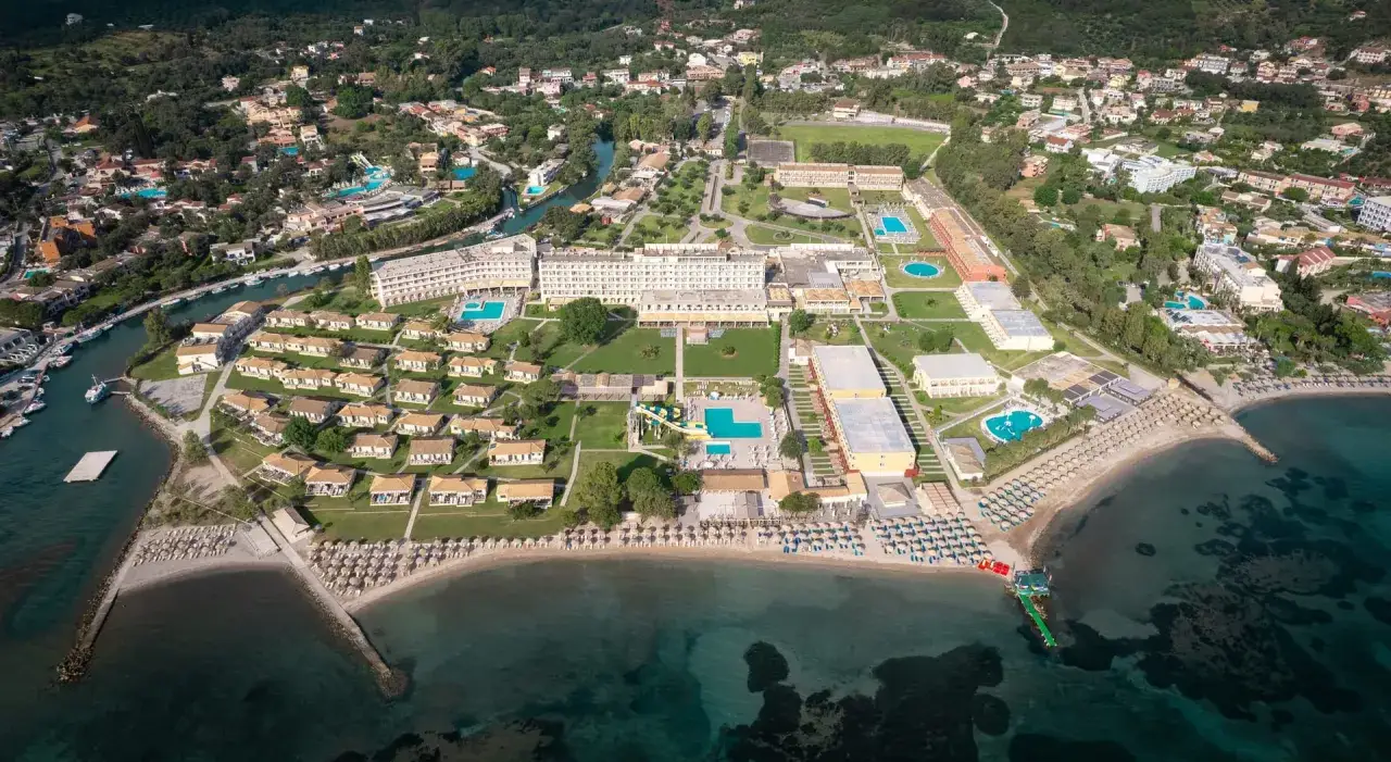 Widok z lotu ptaka na rozległy ośrodek wypoczynkowy przy plaży, z basenami, domkami i hotelem. Idealne miejsce na wakacje, jak sugerują opinie o Messonghi Beach Holiday Resort.