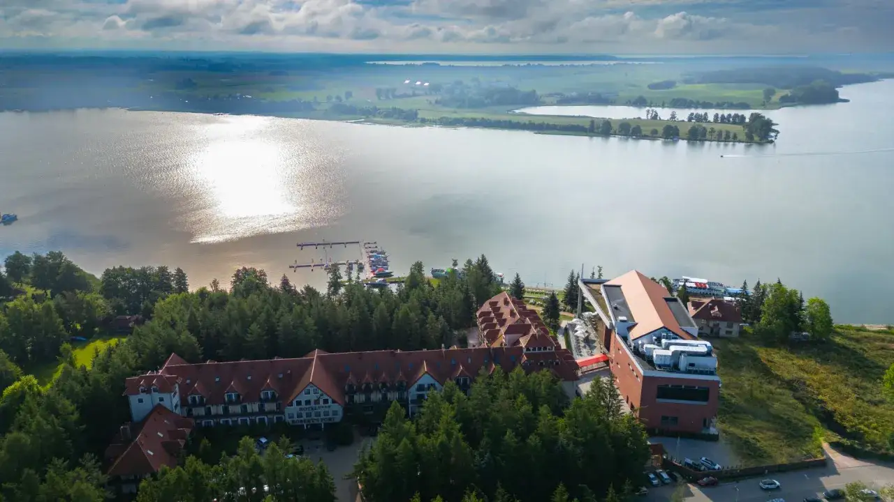 Hotel Robert's Port Lake Resort & Spa na Mazurach, z widokiem na jezioro i przystań. Warto sprawdzić opinie przed rezerwacją.