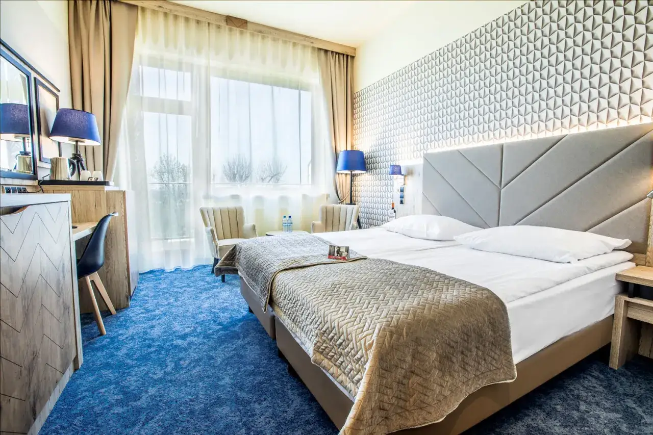 Pokój w hotelu Diament Ustroń. Wygodne łóżko, stylowe meble i widok z okna. Idealne miejsce na relaks, zgodnie z opiniami o spa & wellness hotel diament ustroń.
