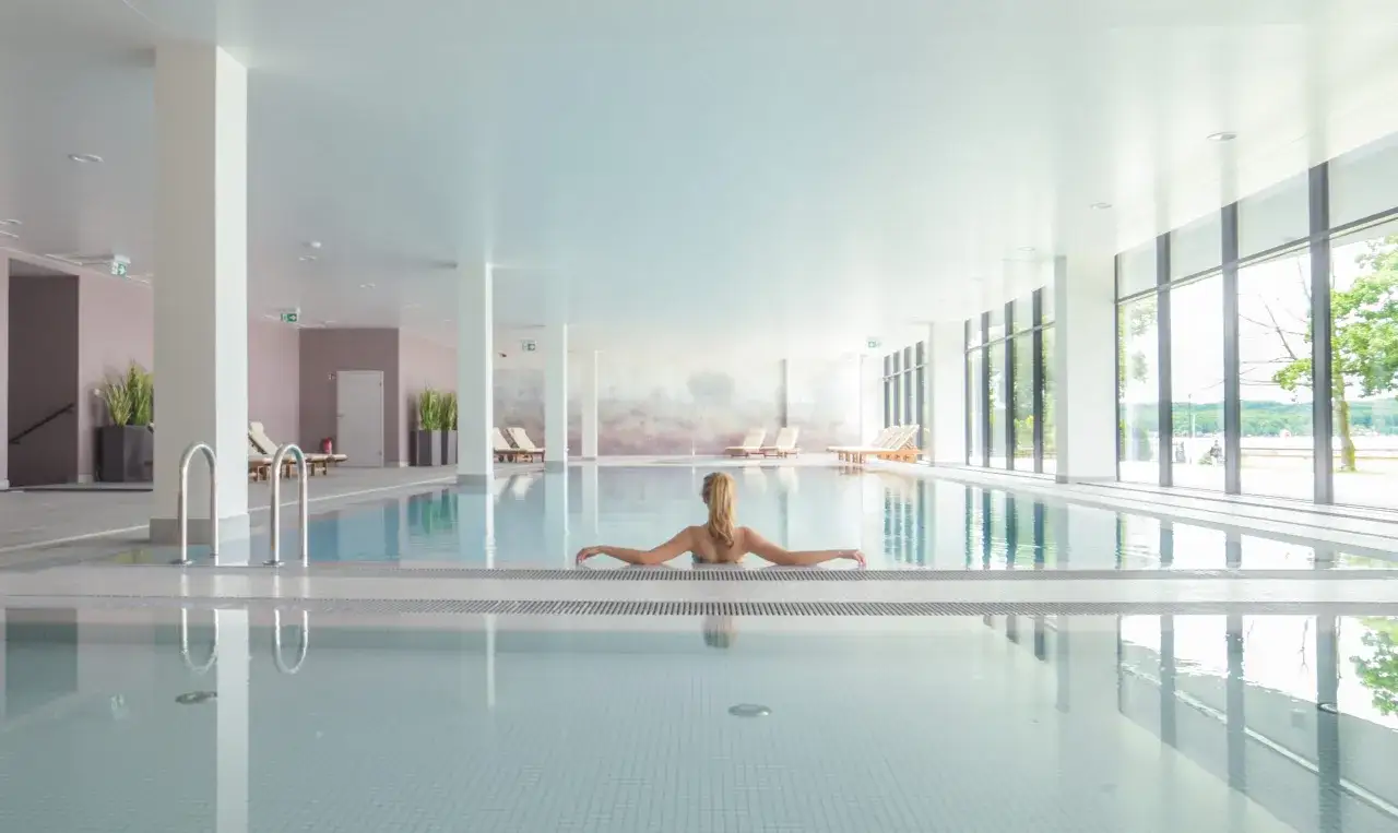 Kobieta relaksuje się w basenie hotelowym. Warto sprawdzić notera hotel spa opinie przed rezerwacją.