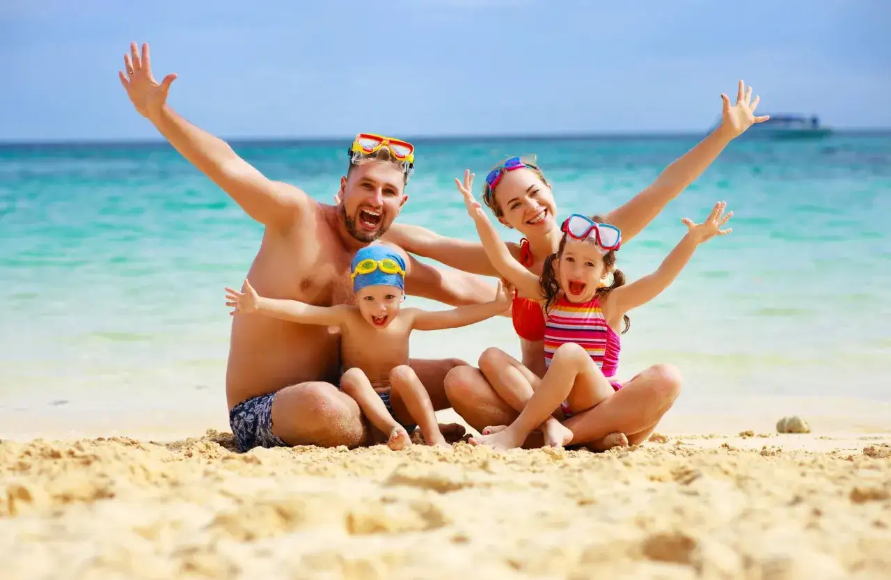 Szczęśliwa rodzina na plaży, w tle błękitne morze. Idealne miejsce na wakacje, jak w Mielnie.