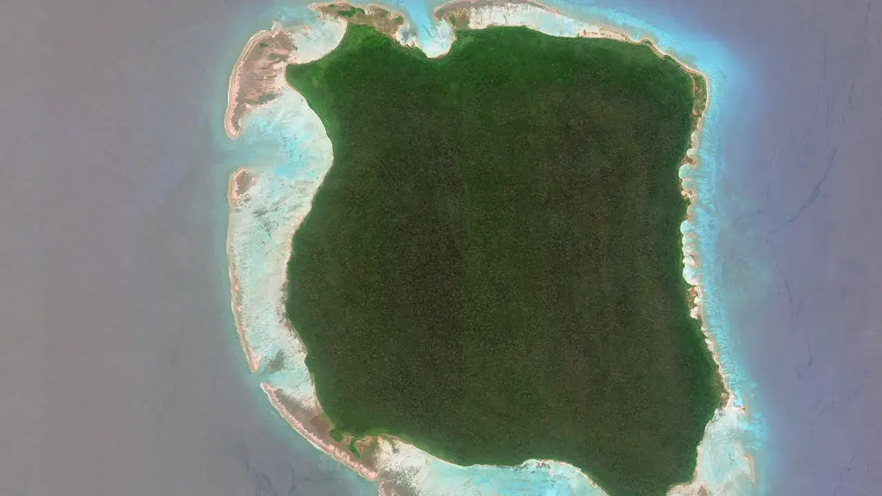 Zielona wyspa porośnięta dżunglą, otoczona turkusową wodą i rafą koralową. To samotny sentinel island, strzegący tajemnic oceanu.