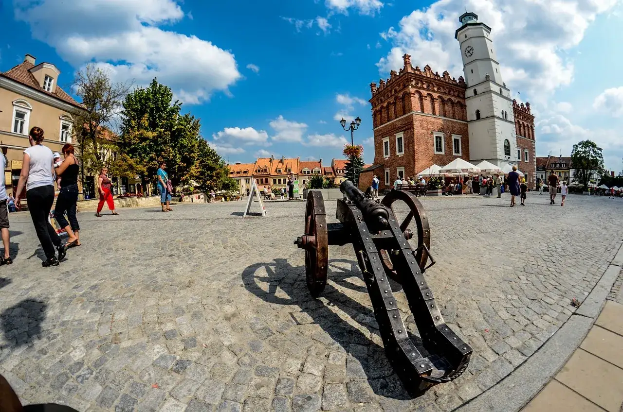 Rynek w najmniejszym mieście w Polsce, z armatą w tle i ratuszem.
