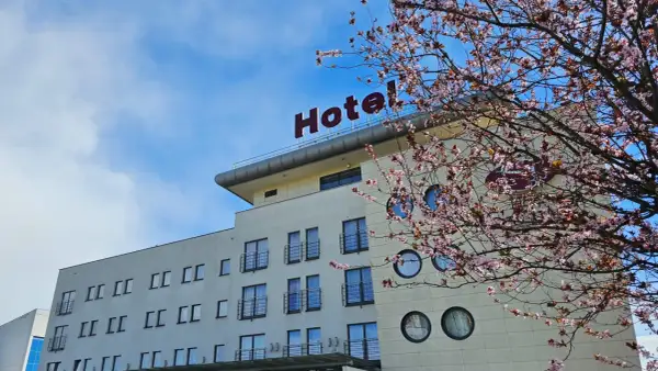 Nowe hotelowe opinie o hotelu z kwitnącą wiśnią w tle.