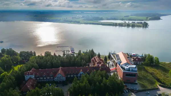 Hotel Robert's Port Lake Resort & Spa na Mazurach, z widokiem na jezioro i przystań. Warto sprawdzić opinie przed rezerwacją.