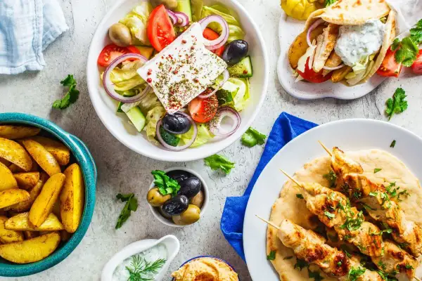 Pyszny grecki posiłek: sałatka grecka, gyros, frytki i hummus. Idealny na letni wieczór z przyjaciółmi.