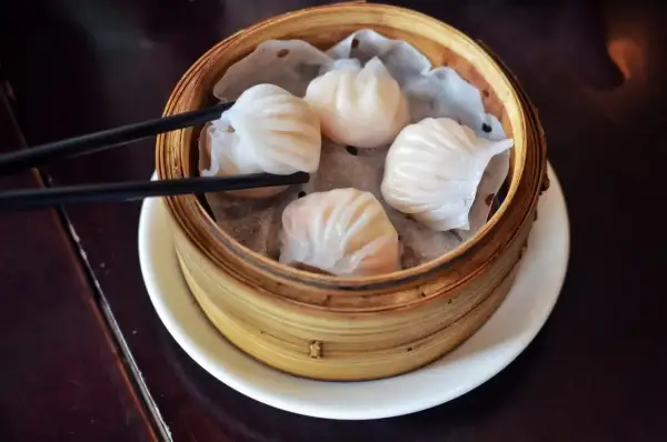 Pyszne dim sum w bambusowym parowniku, gotowe do chwycenia pałeczkami.